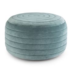 a round blue ottoman that is sitting on top of a white floor and it's made out of fabric