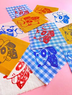 several different colored dog images on napkins with gingham checkered table cloth