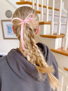 a woman with long blonde hair wearing a pink ribbon around her head and looking down at the stairs