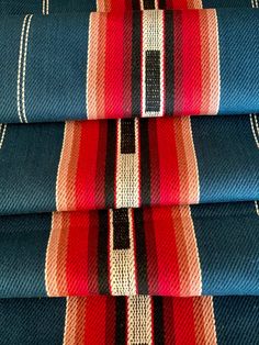 four ties stacked on top of each other in different colors and patterns, all lined up against one another