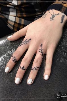 a woman's hand with tattoos on it