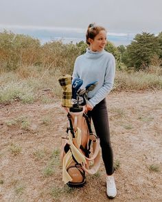 a woman standing next to a golf bag