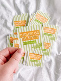 five margaritas and matrimony stickers sitting on top of a bed