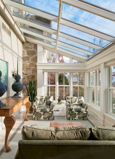 a living room filled with furniture and lots of windows on top of each other's sides