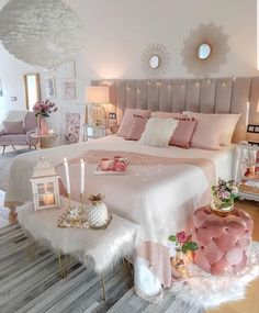 a bedroom decorated in pink and white with candles on the bed