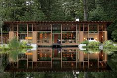 a house that is in the middle of some water with lots of trees around it