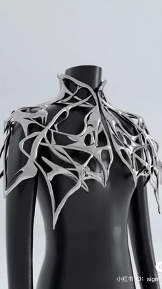 a black mannequin with silver metal designs on it's back and neck