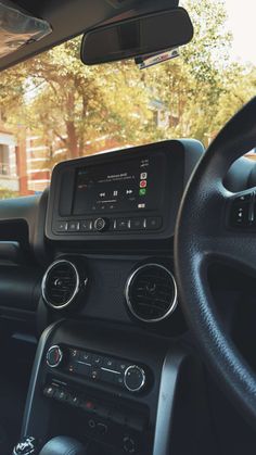 the interior of a car with an electronic display on the dash board and steering wheel