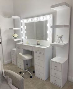 a white vanity with lights on it and a chair in front of the counter top