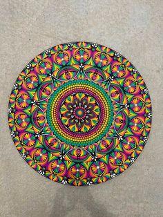 a colorful circular object on the ground with no one around it or someone standing next to it