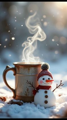 a snowman next to a coffee cup with steam coming out of the top, on a snowy surface