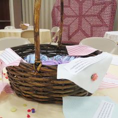 a wicker basket filled with baby's clothes sitting on top of a table