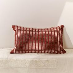 a red and white pillow sitting on top of a bed