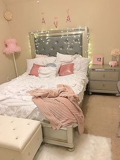 a white bed with pink pillows and blankets on it in a bedroom decorated for valentine's day