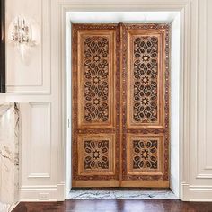 an ornate wooden door in a white room