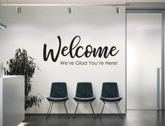 three chairs are sitting in front of a welcome wall decal that says, we're glad you're here