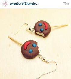 two chocolate donuts with red, blue and white frosting are dangling from hooks