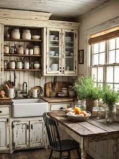 an old fashioned kitchen with wooden floors and white cabinets, including a table that has fruit on it