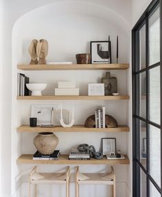 two wooden shelves with books and pictures on them