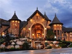 a large stone building with lots of windows and lights on it's front entrance