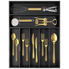 an assortment of golden utensils and spoons in a black tray on a white background