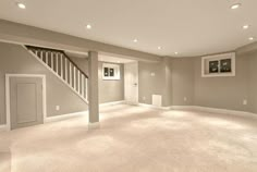 an empty living room with carpet and stairs