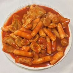 a white plate topped with pasta covered in sauce