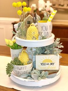 three tiered tray with plants and signs on it that say you are my sunshine