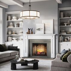 a living room filled with furniture and a fire place in the middle of a room