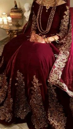 a woman in a maroon dress sitting on a chair