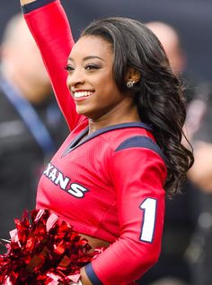 a woman in a red uniform holding a cheerleader's pom - pom