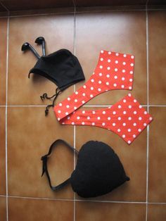 three pieces of clothing are laid out on the floor, including hats and bras