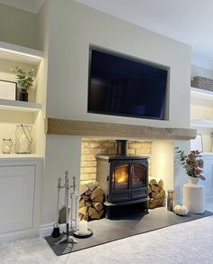 a living room with a fire place and television on the wall above it's fireplace