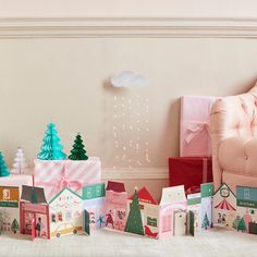 a group of small boxes sitting on top of a floor next to a pink chair