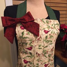 the apron is decorated with holly and red bows