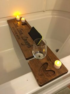 a bath tub with candles and a wooden sign on it