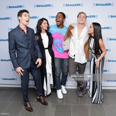 four people standing next to each other in front of a blue and white wall with the words sirius on it