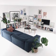 a living room filled with furniture and lots of pictures on the wall next to a coffee table