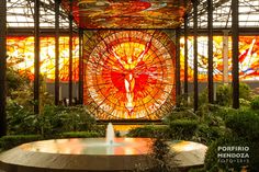 a fountain in front of a stained glass window with the image of jesus on it