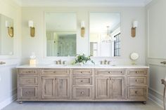 a large bathroom with two sinks and mirrors on the wall next to eachother