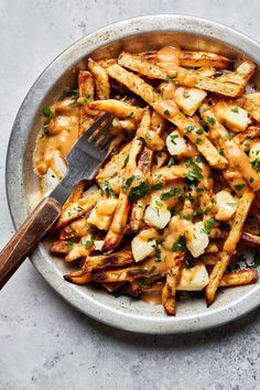 a bowl filled with french fries covered in sauce