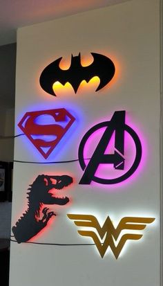 the avengers, superman and wonder logos are lit up in different colors on this wall