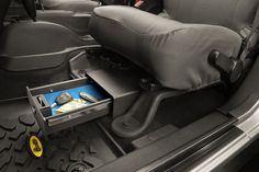 the interior of a car with an open drawer in the back seat and other items on the floor