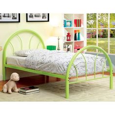 a green metal bed frame sitting on top of a wooden floor next to a book shelf