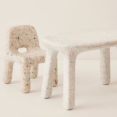 two white plastic chairs and a table with sprinkles on them