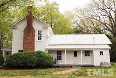 a white house with a chimney in the front yard