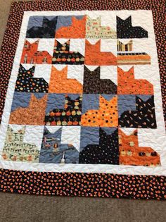 an orange and black cat quilt on the floor