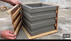 a man is placing cement into a wooden box