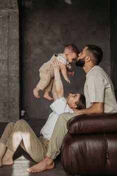 a man and two women are sitting on the floor with a baby in their lap