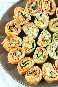 an assortment of appetizers are arranged in a circle on a black platter